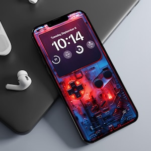 Puede incluir: Un teléfono inteligente negro con una pantalla roja y azul brillante que muestra un reloj digital con la hora 10:14 y la fecha martes 6 de septiembre. La pantalla también muestra una imagen estilizada de un mando de videojuego.