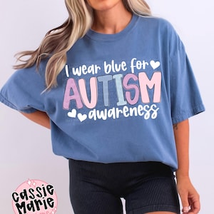 May include: A blue t-shirt with the text "I wear blue for AUTISM awareness" in pink and white lettering with hearts.