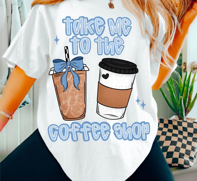 Op de afbeelding: Wit T-shirt met een grafisch ontwerp met twee koffiebekers en de tekst "take me to the coffee shop" in lichtblauw. E&eacute;n beker heeft ijs en een blauwe strik, de andere heeft een zwart deksel en een hart.