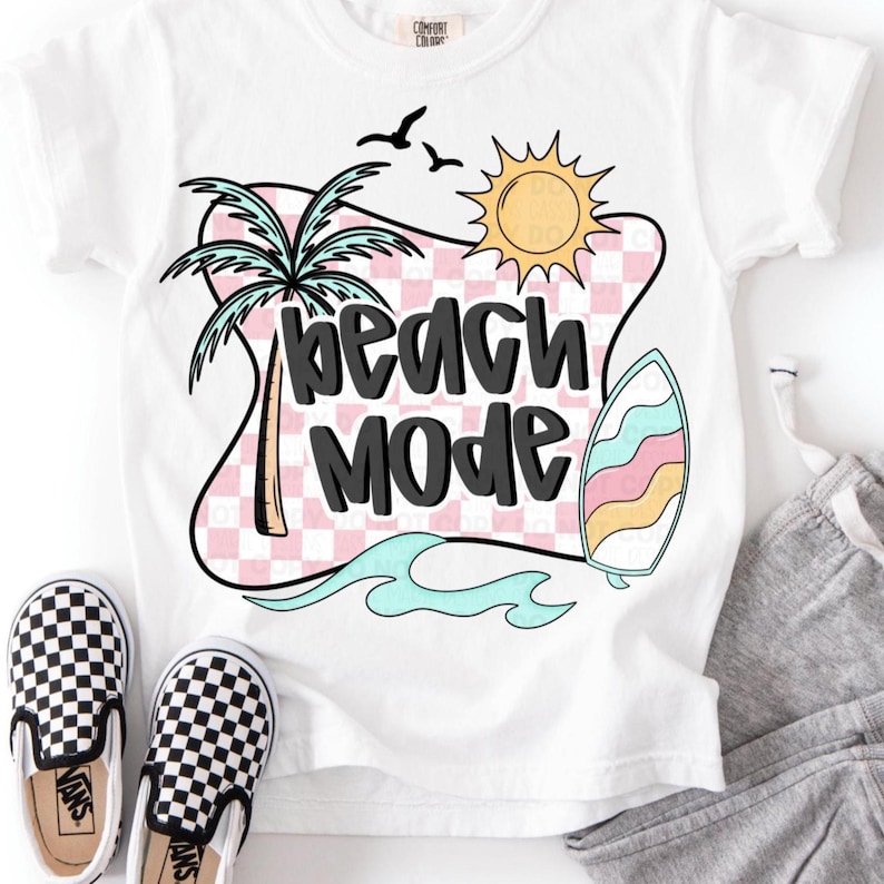 Puede incluir: Camiseta blanca con un dise&ntilde;o a cuadros rosa y blanco, una palmera, un sol, una tabla de surf y el texto "beach mode" en negro.
