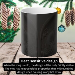 Może przedstawiać: Czarny kubek ceramiczny z termoaktywnym wzorem. Wz&oacute;r jest słabo widoczny, gdy kubek jest zimny, ale ujawni się, gdy wlejesz do niego gorący płyn.
