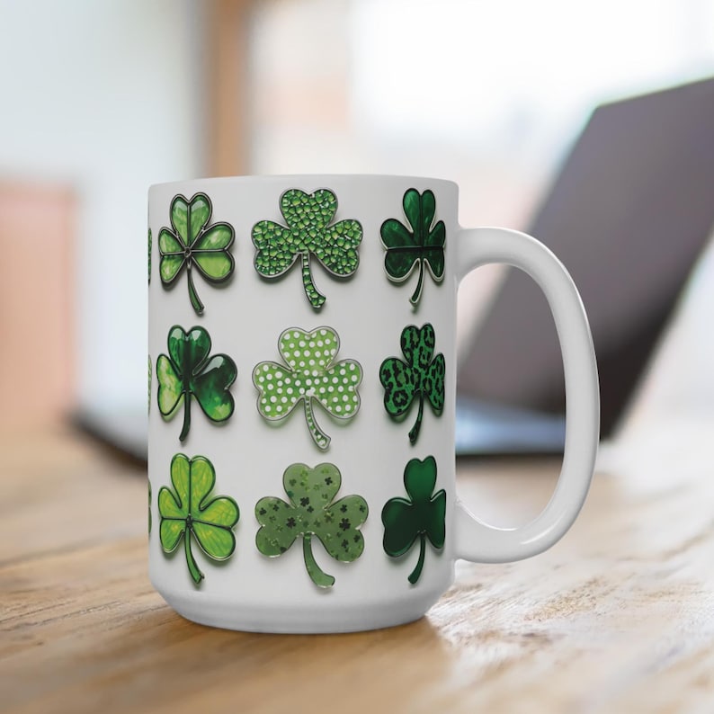 Pu&ograve; includere: Tazza in ceramica bianca con un motivo a trifoglio verde. La tazza ha un manico ed &egrave; decorata con vari disegni di trifoglio.
