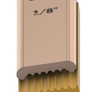 Könnte beinhalten: Ein hellbrauner rechteckiger Block mit abgerundeter Oberkante und einer Reihe vertikaler Rillen im unteren Bereich. Die Oberseite zeigt den eingravierten Text 3mm und 1/8 inch. Unterhalb des Blocks befinden sich zwei kleine runde Perlen.