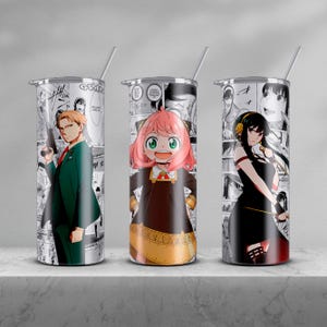 以下が含まれることがあります： 異なるアニメキャラクターがプリントされたステンレス製のタンブラー3つ。タンブラーはすべて同じサイズと形をしており、黒い蓋とストローが付いています。キャラクターは、茶色の髪と緑色のジャケットを着た男性、ピンクの髪と茶色のドレスを着た女の子、黒い髪と黒いドレスを着た女の子です。