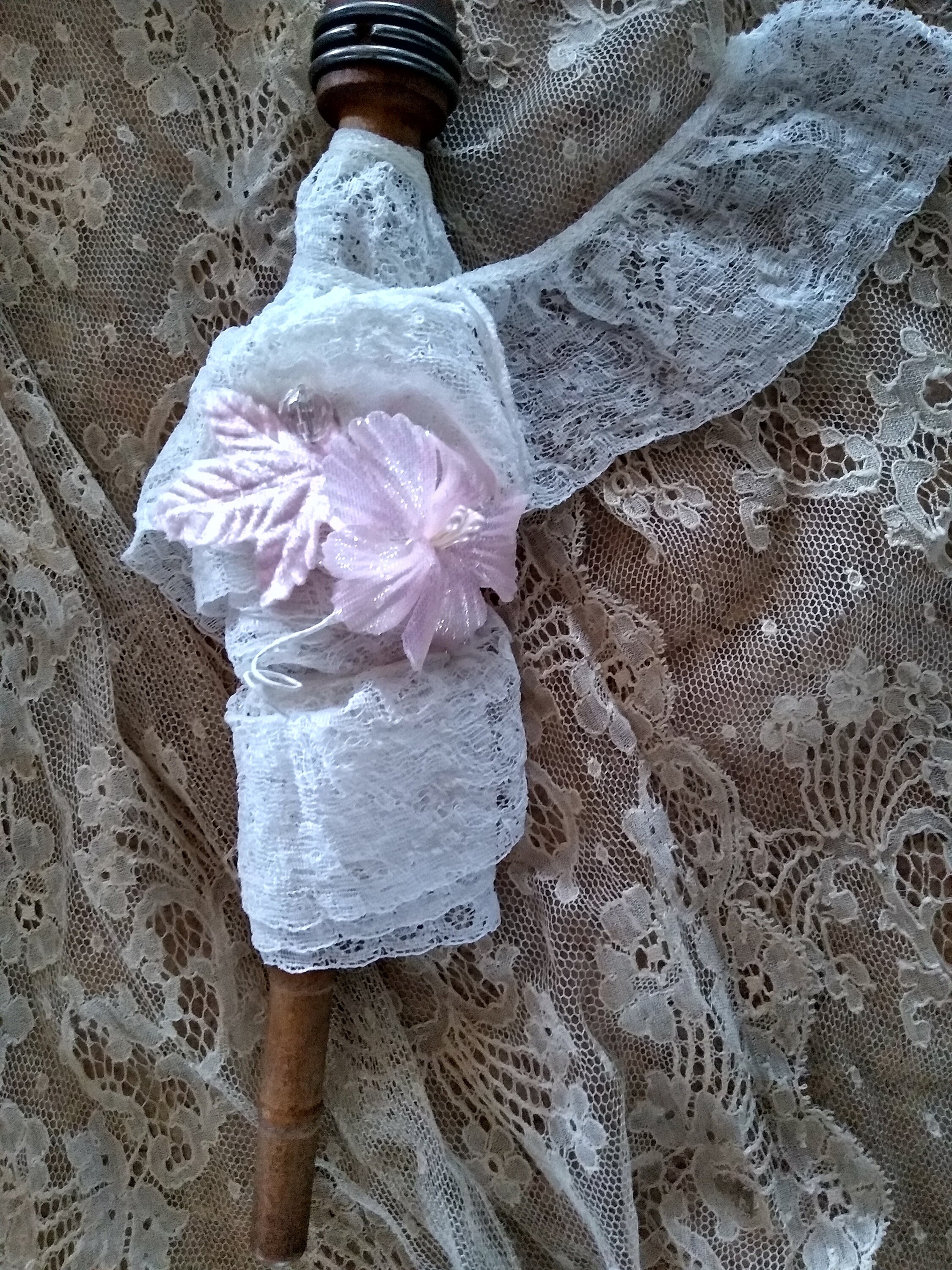 Vintage white lace wrapped around a vintage spool with millinery flowers