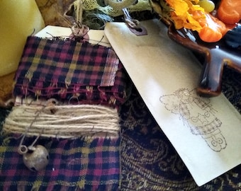 Primitive Homespun Fabric Trim wrapped around a primitive shipping tag& Jute Twine with Rusty Safety  pin and Bell