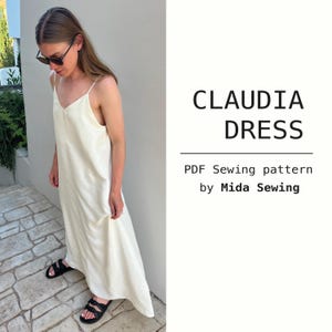 Könnte beinhalten: Eine Frau trägt ein cremefarbenes Slip-Kleid mit dünnen Trägern und schwarzen Sandalen. Das Kleid ist lang und fließend. Der Text rechts lautet "CLAUDIA DRESS" und "PDF Sewing pattern by Mida Sewing."