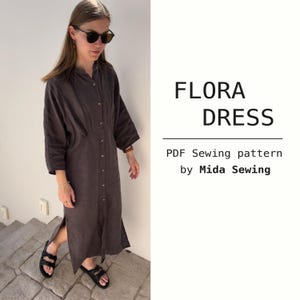 May include: A dark brown, button-down dress with a midi length and side slit. The dress has a collared neckline and three-quarter sleeves. The text "FLORA DRESS" and "PDF Sewing pattern by Mida Sewing" are visible.