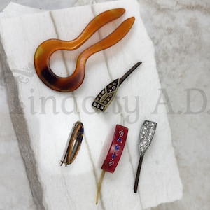 A Collection of Vintage Hair Accessories: A U-Shaped Celluloid Hair Pin, Two Rhinestone Hair Pins and Two Barrettes, Circa 1915-1940&#39;s.