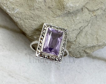 A Vintage Art Deco Style Sterling Silver Ring with Rectangular Rose de France Colored Glass Center Stone Framed in Marcasites, Circa 1940's.