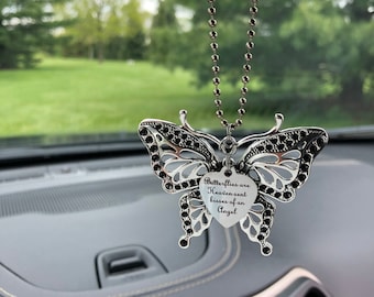 May include: A silver butterfly car charm with a heart-shaped pendant that reads "Butterflies are Heaven-sent kisses of an Angel".