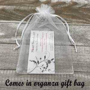 May include: A clear organza gift bag with a white ribbon drawstring. Inside the bag is a business card with the text "Heart Projects, LLC Gifts For The Heart & Soul" and social media information. The words "Comes in organza gift bag" are at the bottom.