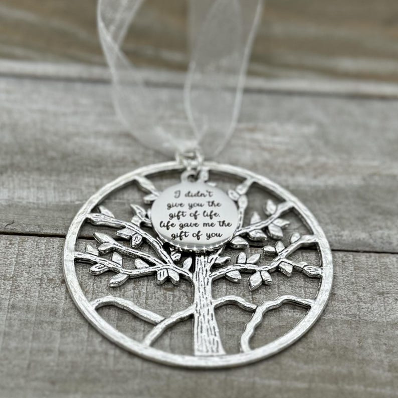 May include: Silver tree of life ornament with a round charm that reads "I didn't give you the gift of life, life gave me the gift of you".