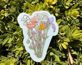 May include: A sticker featuring a bouquet of colorful flowers. The illustration includes orange poppies, white daffodils, yellow flowers, purple irises, and pink blossoms. The sticker has a white border and is set against a background of green foliage.