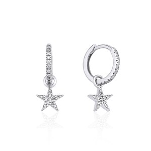 May include: A pair of silver hoop earrings with a star charm dangling from each hoop. The hoops and stars are encrusted with small, clear cubic zirconia stones.