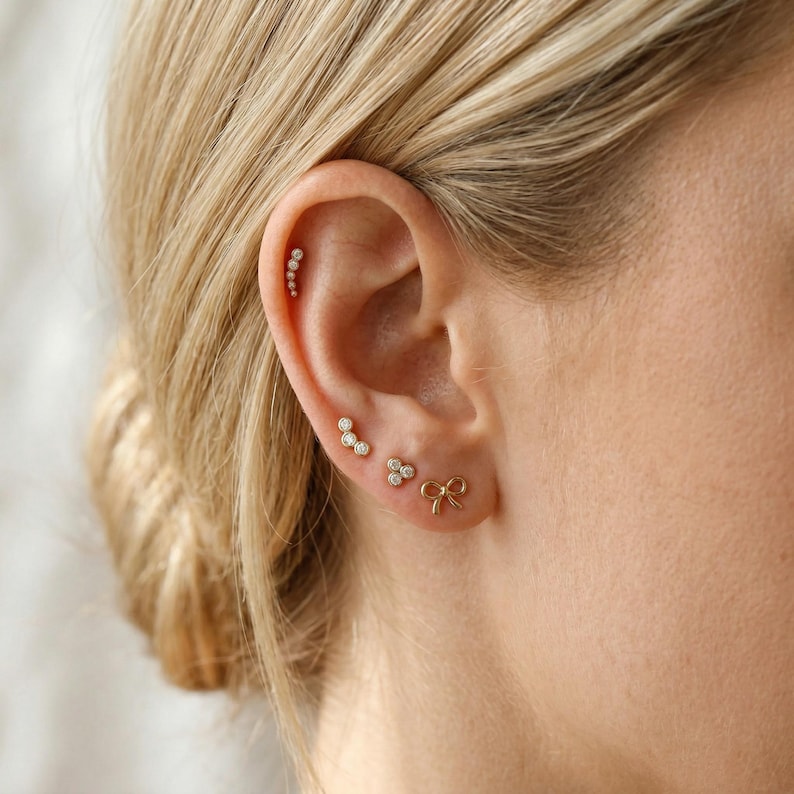 woman wearing 14k gold bow stud earrings flat back cartilage piercing jewelry