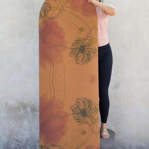 May include: A cork yoga mat with a floral design in shades of brown, green, and pink. The mat features a repeating pattern of stylised flowers and bees.