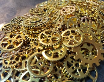 May include: Close-up of a pile of small, gold-colored gears. The gears vary in size and design, with intricate details visible. The image is well-lit, highlighting the metallic sheen of the gears. The gears are likely for a steampunk or jewelry project.
