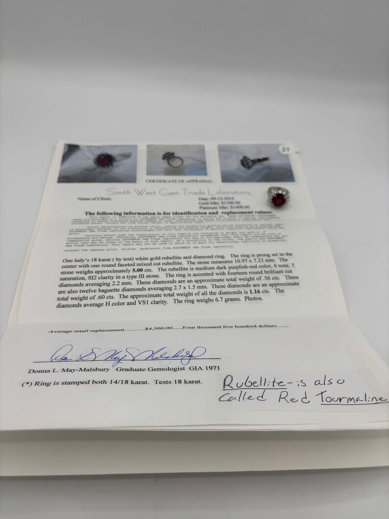 May include: A certificate from South West Gem Trade Laboratory details a white gold ring with a rubellite and diamonds. The ring features a mixed-cut rubellite, approximately 10.97 x 7.23 mm, and fourteen round brilliant-cut diamonds. The ring weighs 6.7 grams.
