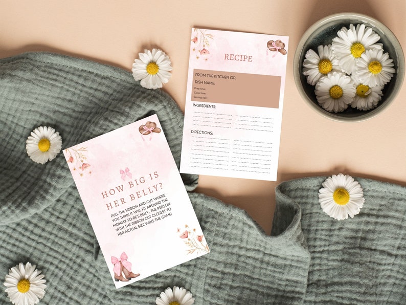 Peut inclure: Une carte de jeu de baby shower rose et marron avec le texte "How big is her belly?" et des instructions pour tirer un ruban et couper o&ugrave; vous pensez qu'il ira autour du ventre de la future maman. La personne dont la coupe de ruban est la plus proche de sa taille r&eacute;elle gagne le jeu.