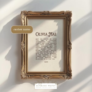 Könnte beinhalten: Gerahmter Druck mit dem Namen "Olivia Mae" in eleganter Schrift. Der Druck zeigt ein Gebet mit dem Wort "Amen" am unteren Rand. Der Rahmen ist verziert mit einer goldenen Oberfläche. Der Druck stammt von "Sunrise Print".