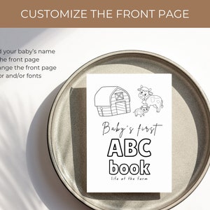 Op de afbeelding: Een zwart-witte illustratie van een schuur, twee koeien en de tekst "Baby's first ABC book life at the farm".