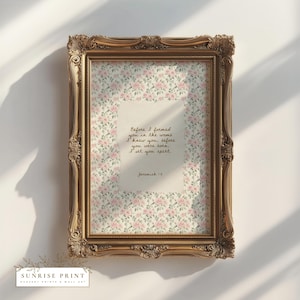 May include: A framed print with a gold ornate frame. The print features a floral pattern with pink roses and a central text area with handwritten text that reads "Before I formed you in the womb...Jeremiah 1:5". The Sunrise Print logo is at the bottom.
