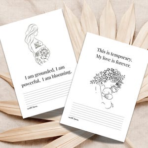May include: Two white cards with black line art and text. One card features a pregnant person illustration and the text: "I am grounded, I am powerful, I am blooming." The other card has a floral illustration and the text: "This is temporary. My love is forever."