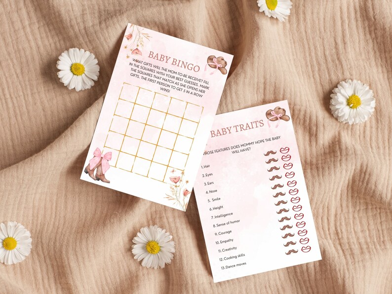 Peut inclure: Deux cartes de jeu de baby shower roses et dor&eacute;es. La premi&egrave;re carte est une carte de bingo avec le titre "Baby Bingo". La deuxi&egrave;me carte est un jeu de traits de b&eacute;b&eacute; avec le titre "Baby Traits".