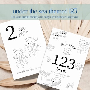 May include: Two black and white coloring pages with an "under the sea" theme. One page features the number "2" and two jellyfish. The other page says "Baby's first 123 book" with ocean-themed illustrations. Text at the top says "Let your guests create your baby's first numbers keepsake."