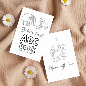Op de afbeelding: Twee zwart-witte printbare kleurplaten voor een eerste ABC-boek voor baby's. De eerste pagina toont een schuur, koeien en de tekst "Baby's first ABC book, life at the farm". De tweede pagina toont een ezel, een schuur en de tekst "Made with love".