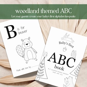 Può includere: Due libri ABC bianchi con illustrazioni di animali del bosco. Un libro presenta un castoro e la lettera "B". L'altro libro si intitola "Baby's first ABC book" con illustrazioni di animali del bosco. Il testo "woodland themed ABC" è in alto.