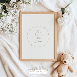Puede incluir: Una impresión enmarcada con el texto "Jesus loves me this I know" rodeada por una corona de hojas verdes. La impresión está en un marco de madera clara, sobre una tela blanca, con un osito de peluche y flores blancas.