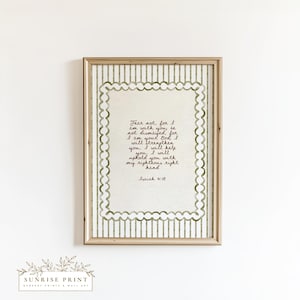 Può includere: Stampa artistica da parete incorniciata con una citazione da Isaia 41:10 in elegante scrittura. L'opera d'arte ha uno sfondo beige chiaro con un bordo smerlato e un motivo a righe. La cornice è di colore marrone chiaro.