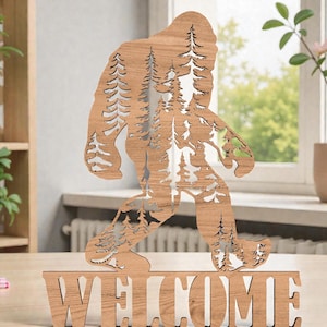 May include: A wooden Bigfoot silhouette with a forest scene cut out, standing above the word "WELCOME". The brown wooden figure is a decorative item, perfect for a cabin or nature-themed decor. The design features a walking Bigfoot with trees inside.
