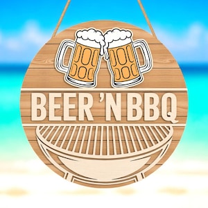 Puede incluir: Un letrero redondo de madera con la inscripción "BEER 'N BBQ" en blanco. El letrero presenta un gráfico de dos jarras de cerveza y una parrilla. El letrero está colgado de una cuerda, con un fondo de playa.