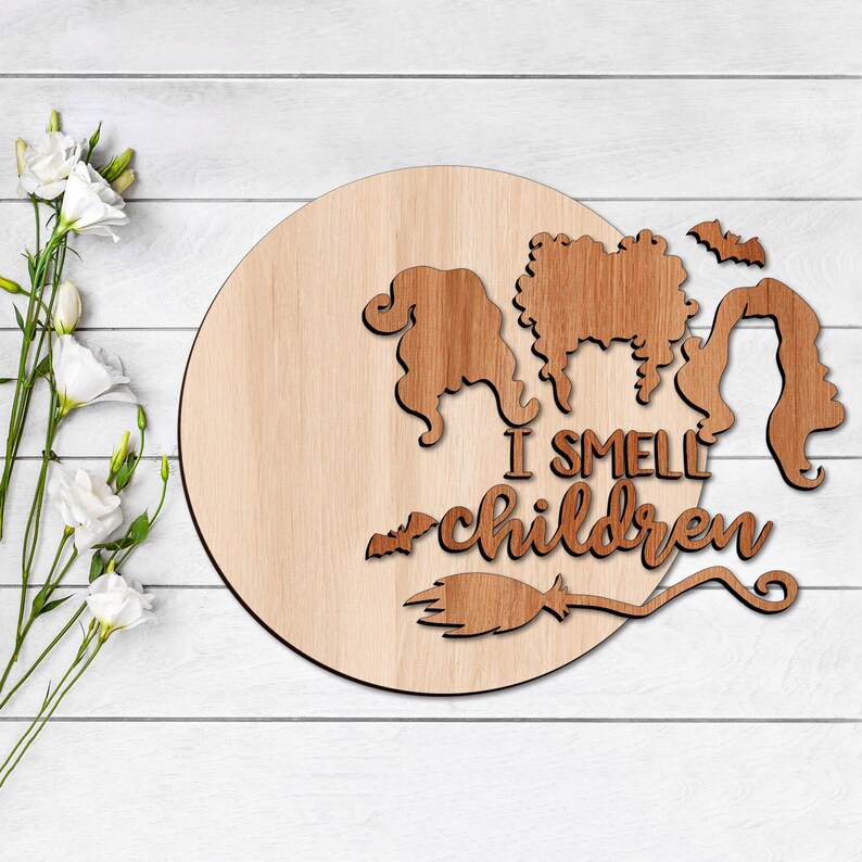 May include: Wooden round sign featuring a witch's silhouette and the text "I smell children" with a broom underneath.