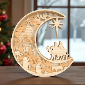 May include: A wooden crescent moon-shaped nativity scene. The layered design features silhouettes of the Holy Family, camels, and a star. The natural wood tones create a warm, inviting aesthetic, perfect for holiday decor.