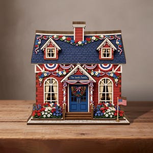May include: A miniature red house with a blue roof, decorated with red, white, and blue bunting and floral garlands. The front door features a wreath and a sign reading The Smith Family. A small American flag stands on the right side.