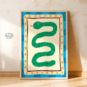 Puede incluir: Una ilustración enmarcada de una serpiente verde con un borde amarillo y azul. La serpiente está enroscada en forma de S vertical. El fondo es de color amarillo claro.