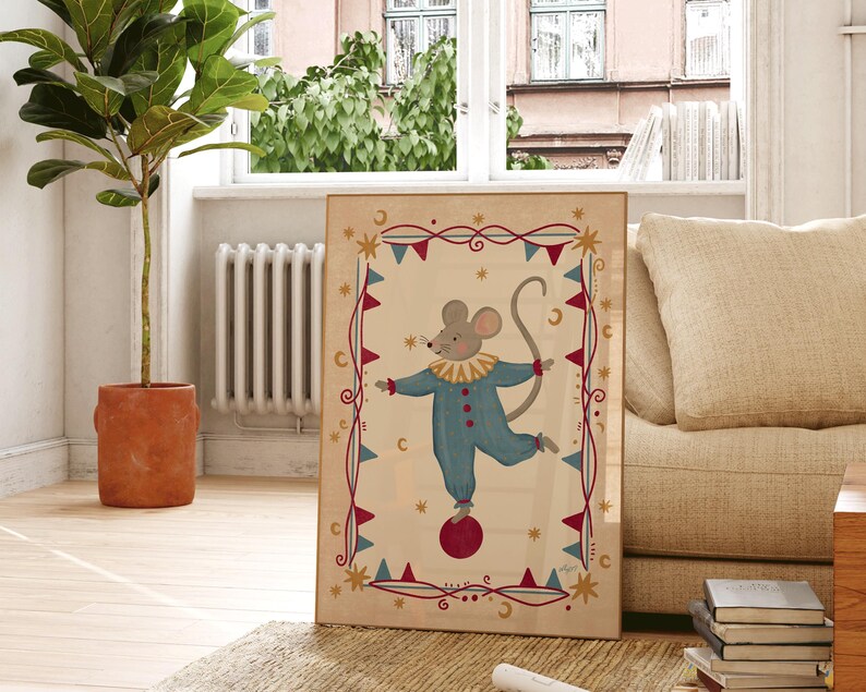 May include: A framed rectangular wall art print featuring a central illustration of a grey mouse wearing a blue clown suit with a yellow ruffled collar, balancing on a red ball, surrounded by a decorative border of red and blue triangular flags.