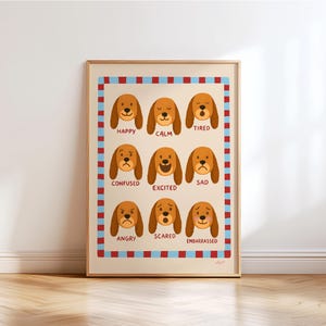 Puede incluir: Una impresión enmarcada con nueve caras de perros de dibujos animados, cada una expresando una emoción diferente: feliz, tranquilo, cansado, confundido, emocionado, triste, enojado, asustado y avergonzado. La impresión tiene un fondo beige con un borde azul y rojo.
