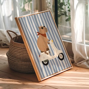 Pode incluir: Uma impress&atilde;o art&iacute;stica emoldurada com uma capivara numa scooter branca. A capivara usa &oacute;culos de sol e uma bandana vermelha contra um fundo listrado azul e branco. A moldura &eacute; castanho-claro. Uma cesta de vime est&aacute; &agrave; esquerda da impress&atilde;o.