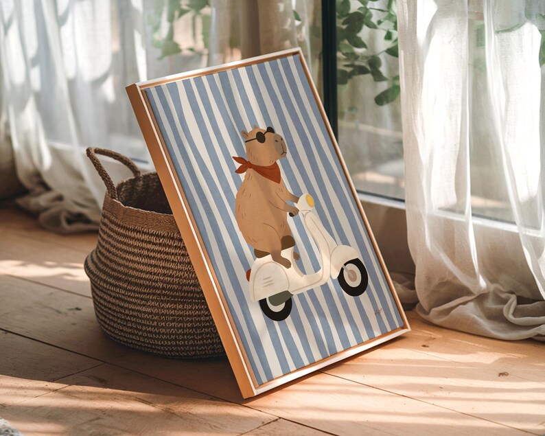 Pode incluir: Uma impress&atilde;o art&iacute;stica emoldurada com uma capivara numa scooter branca. A capivara usa &oacute;culos de sol e uma bandana vermelha contra um fundo listrado azul e branco. A moldura &eacute; castanho-claro. Uma cesta de vime est&aacute; &agrave; esquerda da impress&atilde;o.