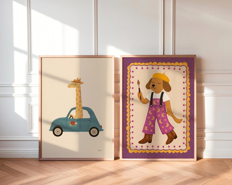 Op de afbeelding: Twee ingelijste kunstdrukken. E&eacute;n toont een giraffe die in een blauwe auto rijdt met bloemendetails. De andere toont een hondenkunstenaar met een gele baret en paarse overall met maandetails, die een penseel vasthoudt.
