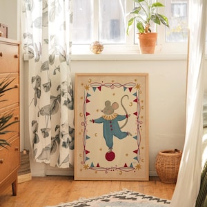 May include: A framed rectangular wall art print featuring a central illustration of a mouse wearing a blue clown suit with a yellow ruffled collar, balancing on a red ball. The border includes red and blue bunting, gold stars, and crescent moons.