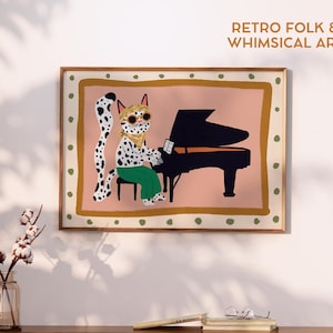 May include: A framed art print featuring a whimsical illustration of a spotted cat playing a black grand piano. The cat wears sunglasses and green pants. The print has a pink background and the text "RETRO FOLK & WHIMSICAL ART".