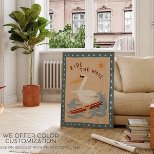 May include: A framed poster with a pelican wearing sunglasses surfing a wave. The poster has the text "Ride the Wave" and a sun graphic. The poster is in a room with a plant, a couch, and a window.