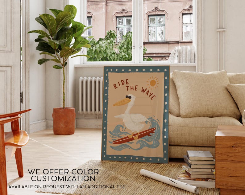 May include: A framed poster with a pelican wearing sunglasses surfing a wave. The poster has the text "Ride the Wave" and a sun graphic. The poster is in a room with a plant, a couch, and a window.