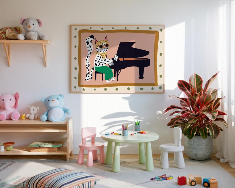 May include: A colorful illustration of a spotted cat wearing sunglasses playing a piano, framed and hanging on a white wall in a child's playroom. There are two small pink and white chairs and a green table with colorful pencils in front of the picture. A potted plant with red and green leaves is in the corner of the room.